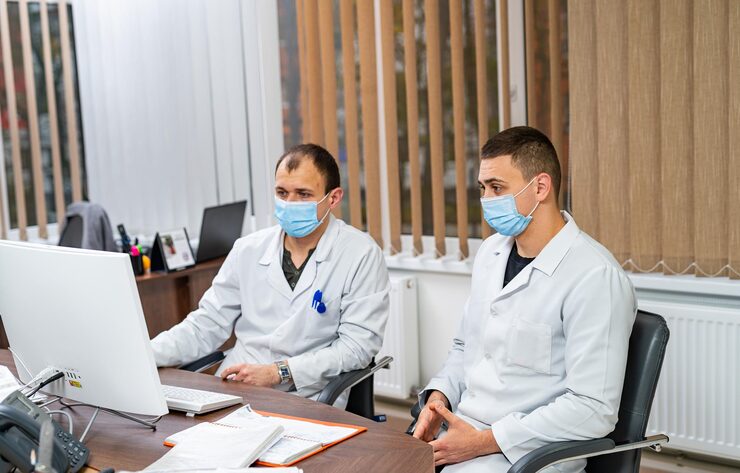 doctors discussing patient care modern clinic two healthcare professionals masks collaborate patient cases clinic focused their computer work 116317 71135